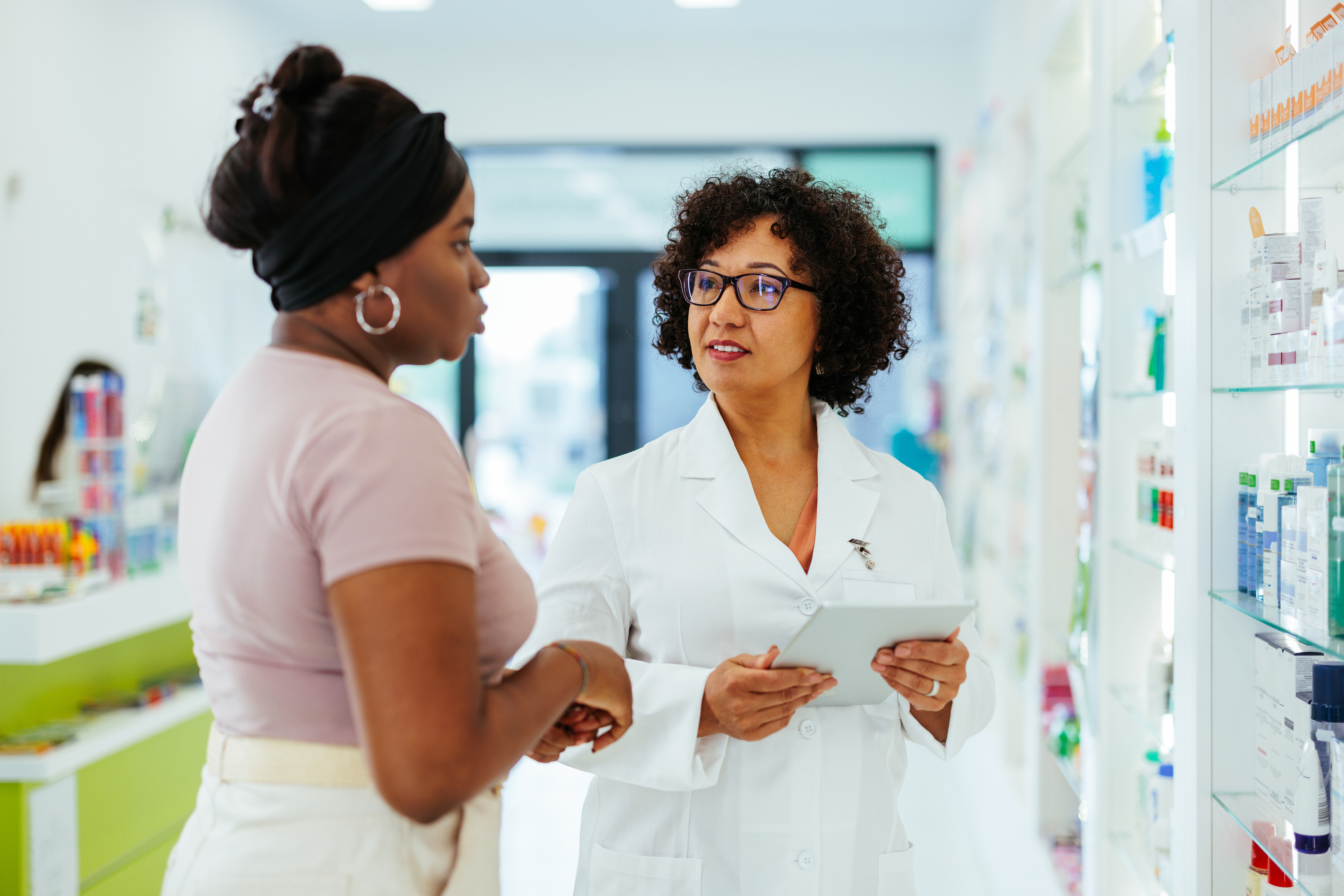 Patient in retail pharmacy talking to pharmacist